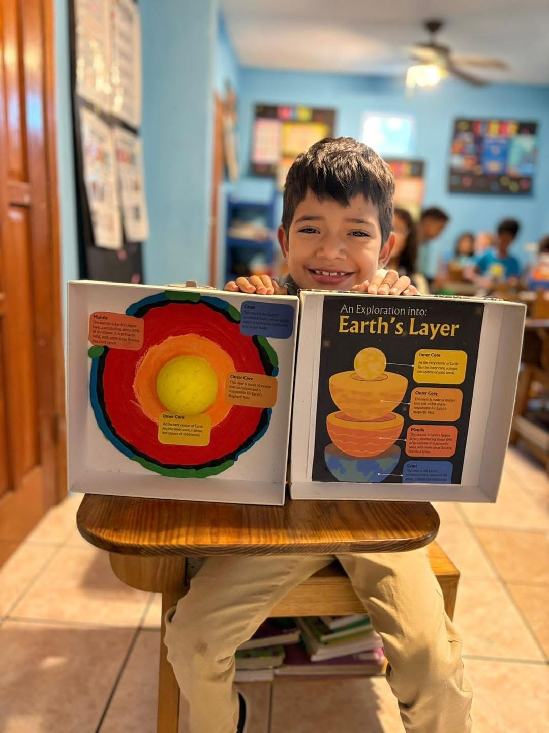 Student proudly displaying an Earth's layers project in the classroom